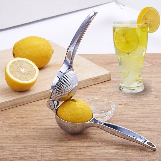 presse agrume sur comptoir bois avec citron a l interieur et verre et citrons