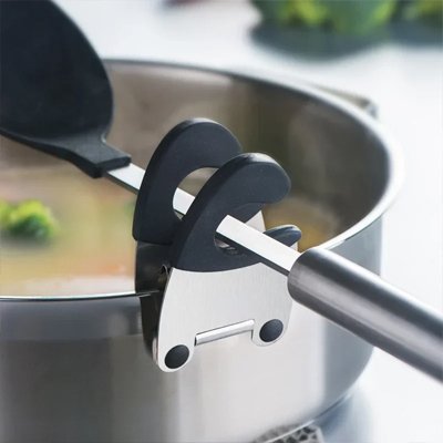 casserole inox avec cuillere noir sur repose cuillere noir gros plan