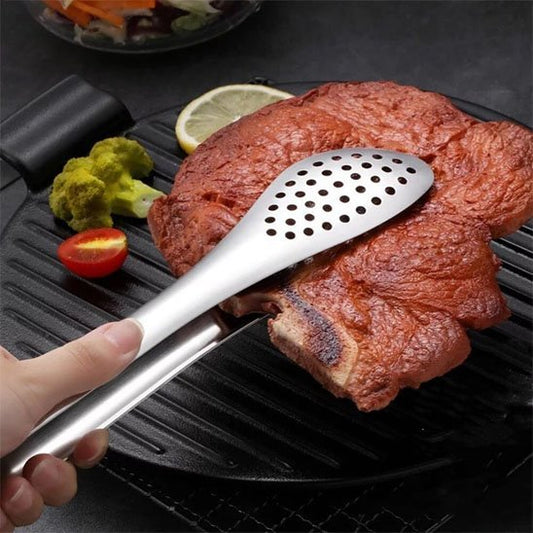 grosse piece de viande et pince cuisine sur grille avec tomate brocoli et citron