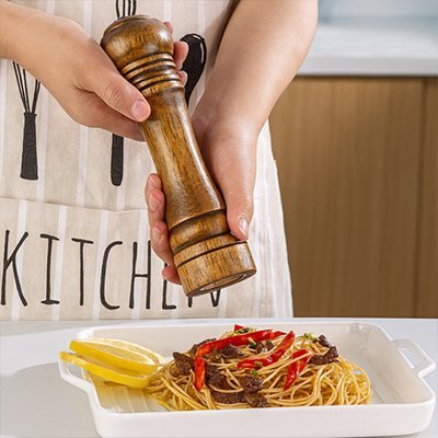 homme tablier kitchen avec moulin a poivre marron sur pates