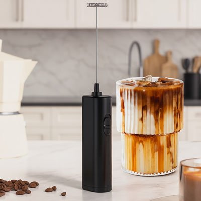 mousseur a lait electrique avec verre coulises et grains de cafe dans cuisine blanche