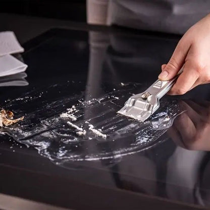 nettoyage avec grattoir plaque induction residu blanc serviette blanche