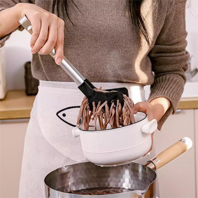 nouilles brunes bol blanc pince de cuisine femme chandail brun