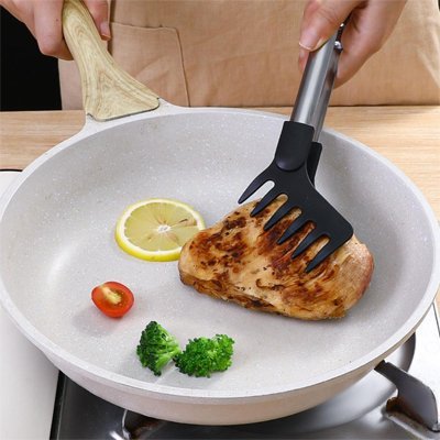 piece de viande avec pince de cuisine dans poele grise brocoli tomate et citron