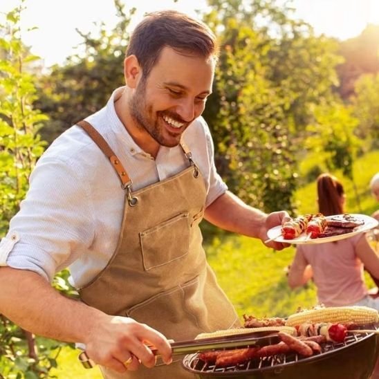 saucisses sur barbecue et homme avec tablier de cuisine brun 